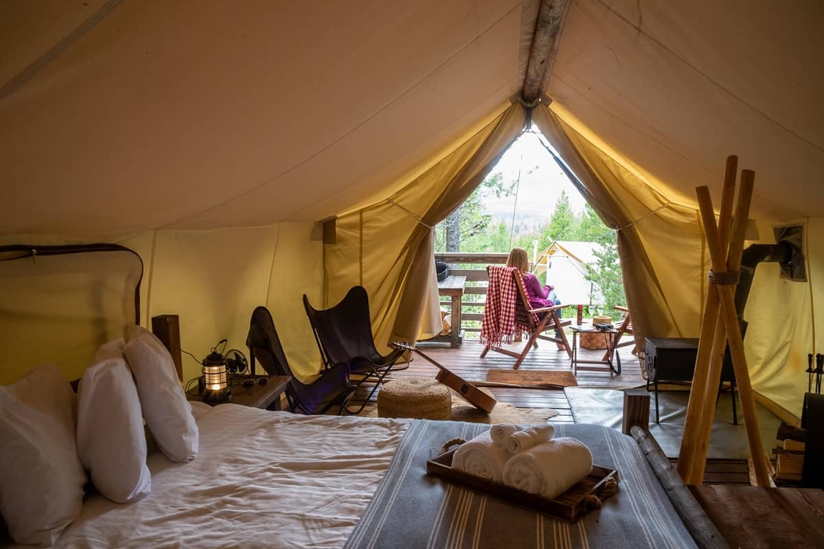 A woman sits inside a luxurious canvas tent