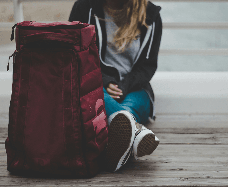 A student sits with her school backpack