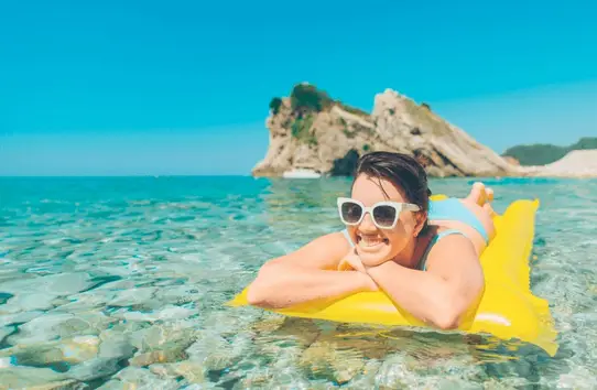 A photo of a woman in the water on a pool float.