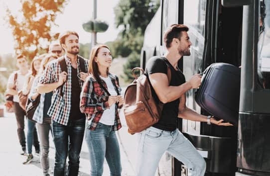 A photo of travelers getting on a bus.